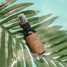 After Sun Aloe Vera Sunburn Spray 2 oz amber spray inside of a pool of water balancing on a palm leave