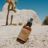 Bug spray that is an insect repellent and bug bite relief. 4 oz bottle in the dessert next to a joshua tree