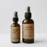 Relaxing essential oil based pillow sprays. One 2 oz amber glass bottle and one 4 oz bottle in front of a white background.